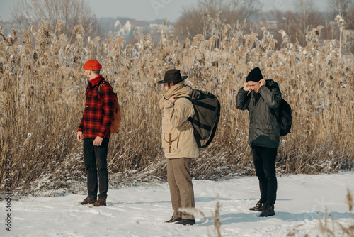 Group of people hiking with bagpacks. Winter vacation. Group of young tourists enjoying The cold weather. Friendship. photo