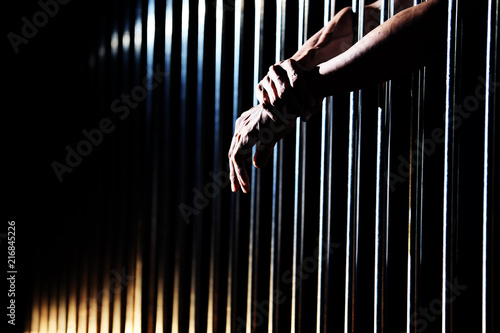 Fototapeta close up of prisoner hands in jail.