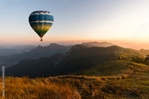 Colorful hot air balloons fly in the mountains with sunrise. the mountain and travel concept