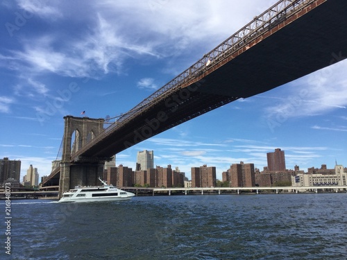White boat under Brooklyn Bridge
