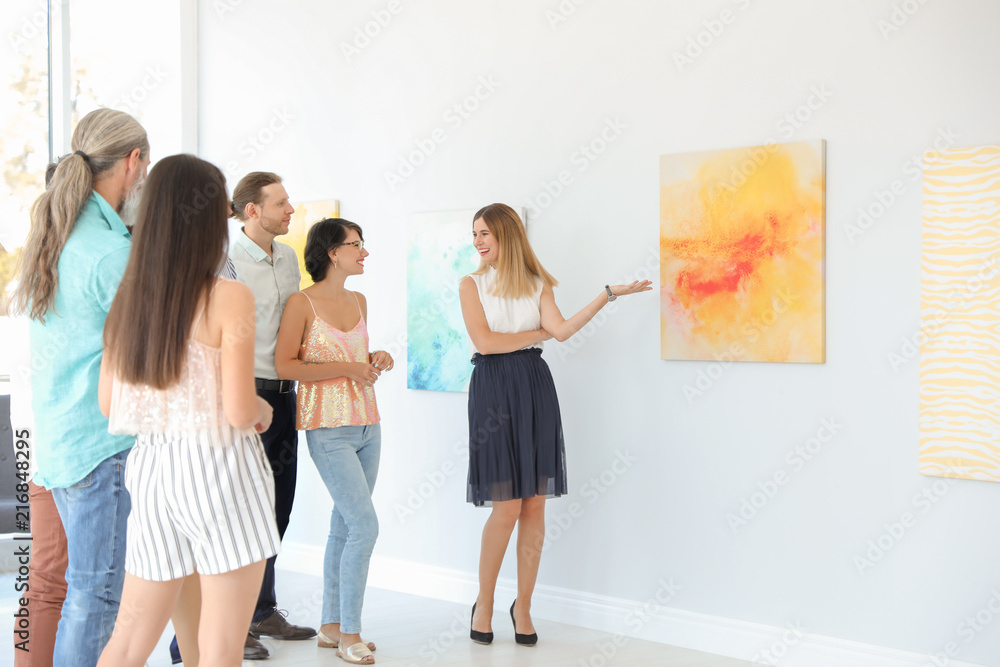 Group of people with guide at exhibition in art gallery Group of people with guide at exhibition in art gallery