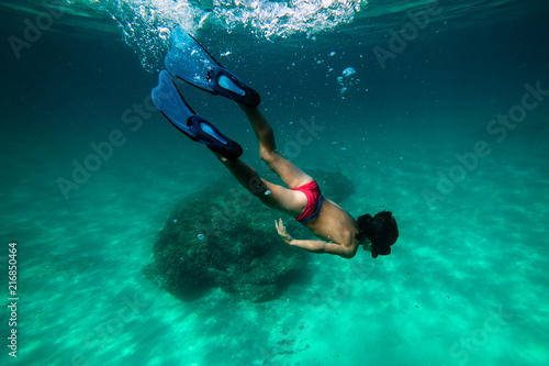 Anonymous boy snorkeling in sea photo