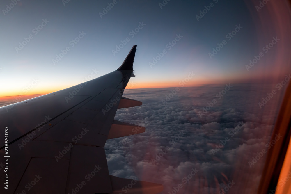 view from the airplane window to the wing, evening, sunset, clouds, concept of night voyages and travels view from the airplane window to the wing, evening, sunset, clouds, concept of night voyages and travels