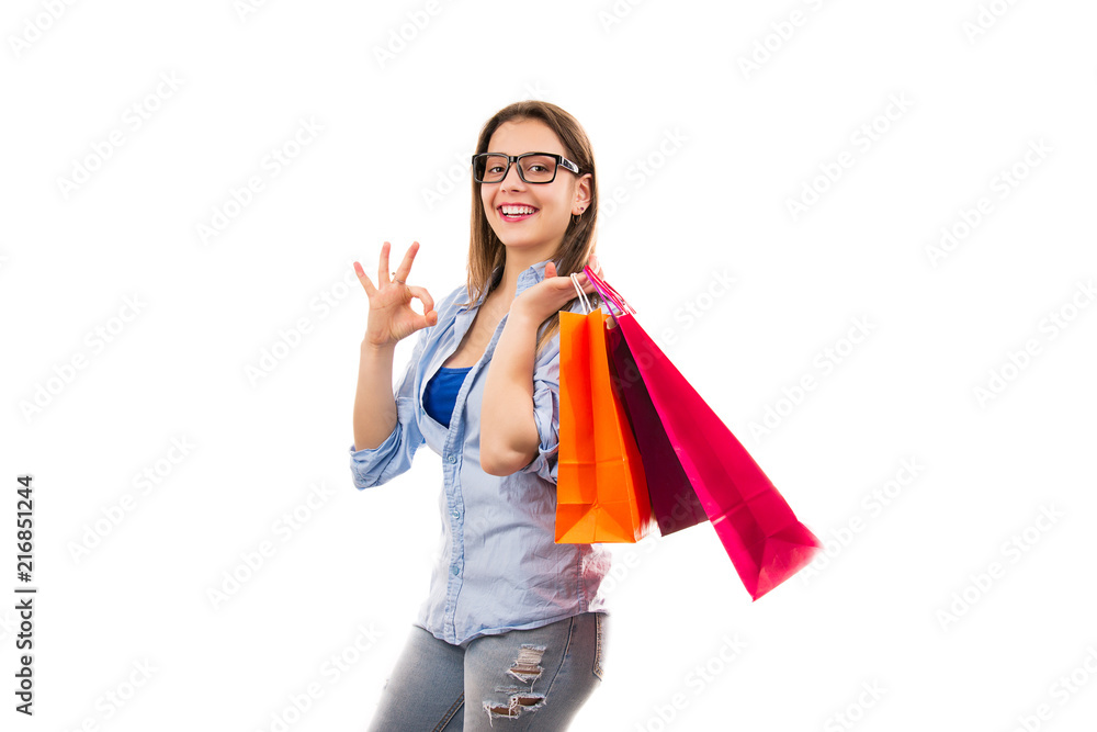 Content woman with shopping bags showing OK gesture Content woman with shopping bags showing OK gesture