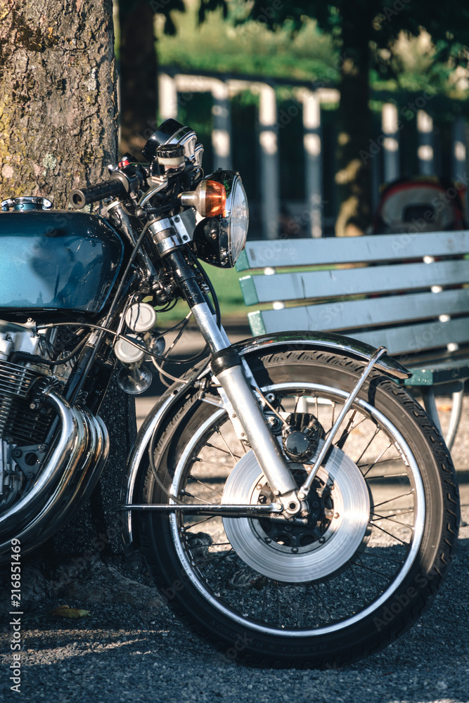 close up of detail of classic style cafe racer motorcycle at sunset time. Bike custom made in vintage. Brutal fun urban lifestyle, vertical photo close up of detail of classic style cafe racer motorcycle at sunset time. Bike custom made in vintage. Brutal fun urban lifestyle, vertical photo