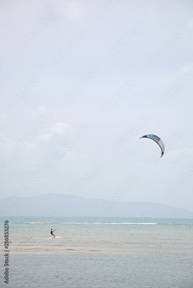 A man is kiting near a beach in Thailand A man is kiting near a beach in Thailand