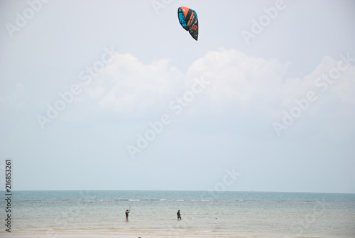 A man is kiting near a beach in Thailand