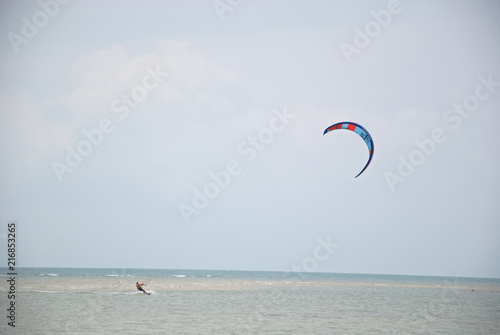 A man is kiting near a beach in Thailand
