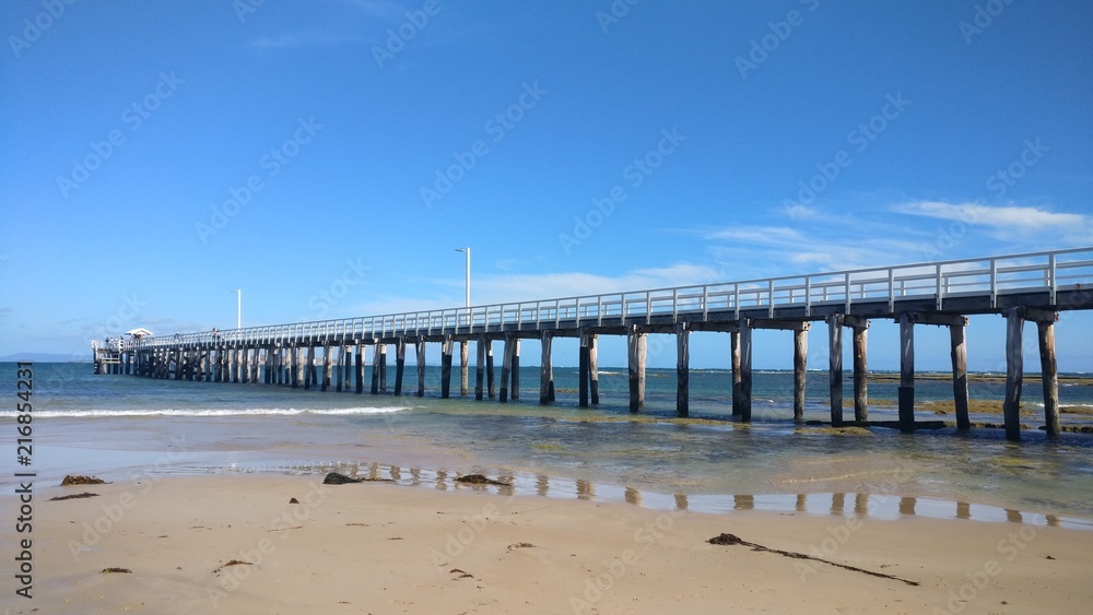 Long pier on shallow beach