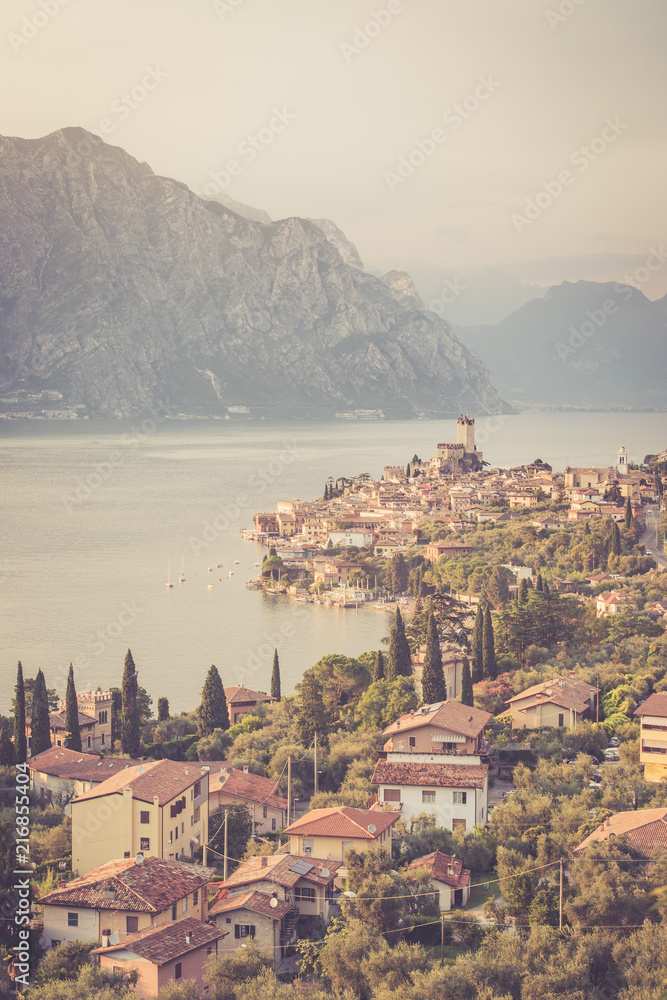 Ausblick auf Malcesine, Gardasee, Italien. Italienische Häuser, See, Berge und Plfanzen. 