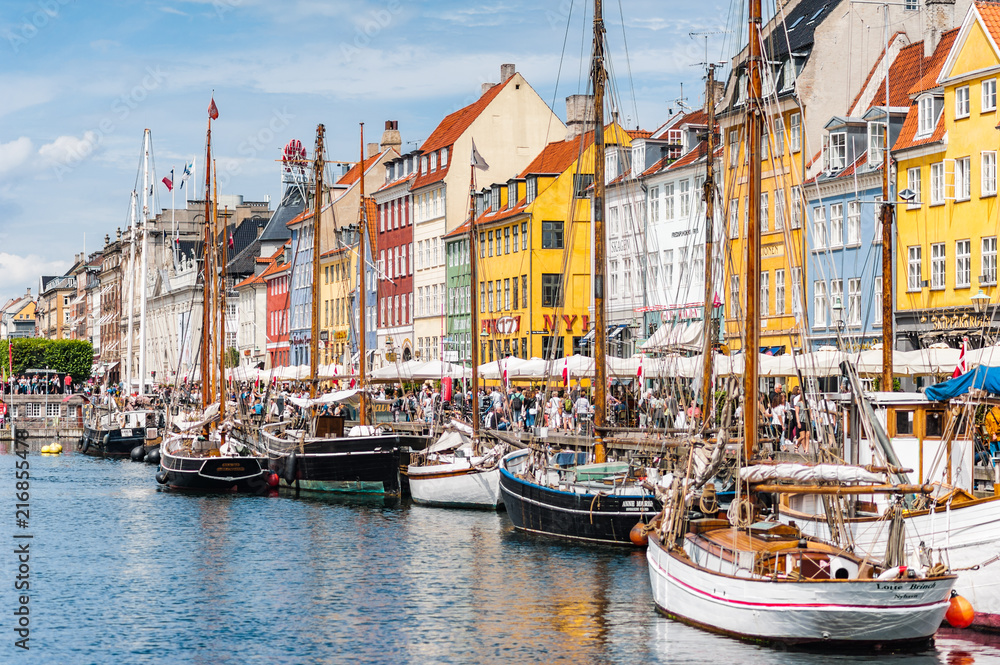 Scenic summer view of Nyhavn pier. Colorful building facades with boats and yachts in the Old Town of Copenhagen, Denmark