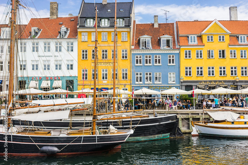 Scenic summer view of Nyhavn pier. Colorful building facades with boats and yachts in the Old Town of Copenhagen, Denmark