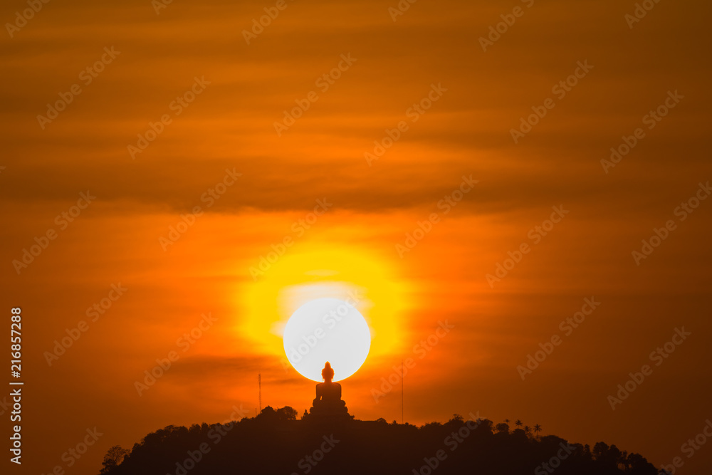 stunning red sky sunset the round sun is on the back of Phuket big Buddha on the high mountain .landmark of Phuket island can see isolated Phuket big Buddha from distance stunning red sky sunset the round sun is on the back of Phuket big Buddha on the high mountain .landmark of Phuket island can see isolated Phuket big Buddha from distance