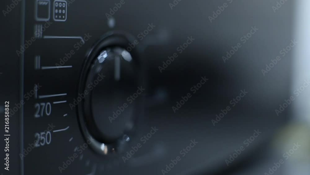 finger presses the buttons and adjusts the temperature of the modern oven, microwave. convenient lever in home appliances. finger presses the buttons and adjusts the temperature of the modern oven, microwave. convenient lever in home appliances.