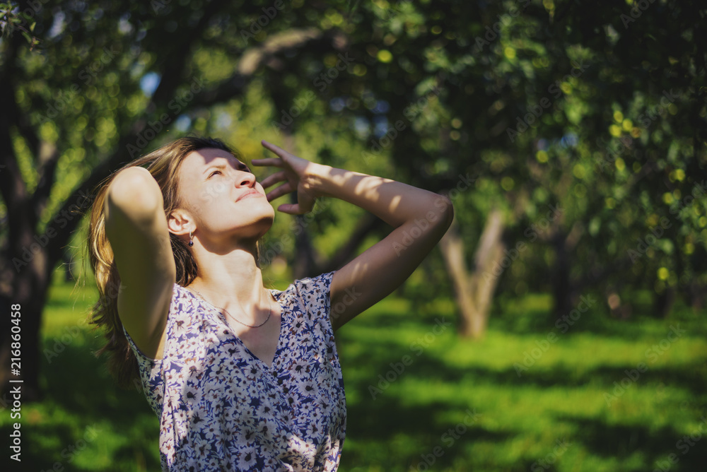 Young attractive woman adjusting her hair in the garden Young attractive woman adjusting her hair in the garden