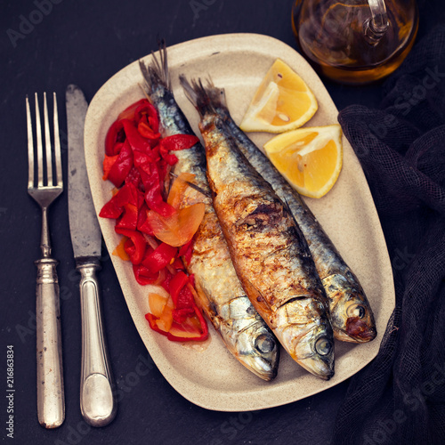 grilled sardines with red pepper and lemon on dish