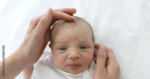 Mother stroking the child to feel the fontanel of 1 months baby girl