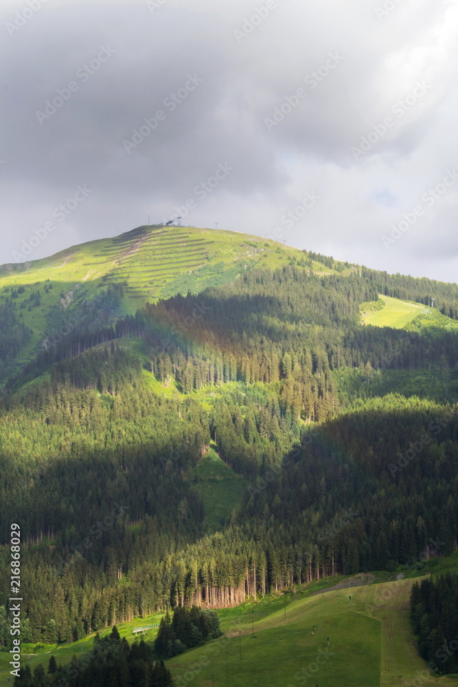 Obraz premium Rainbow over valley with Schattberg Mountain in background, Saalbach-Hinterglemm, Alps, Zell am See district, Salzburg federal state, Austria 
