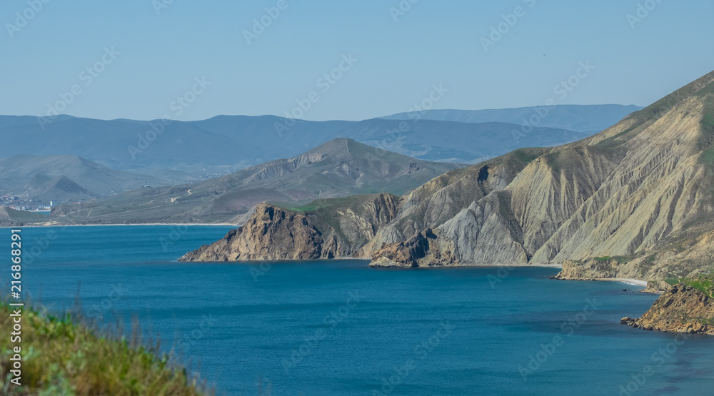 Fototapeta premium Beautiful green slopes of the mountains by the sea.