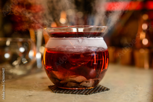 Alcoholic cocktail with steam row on bar table