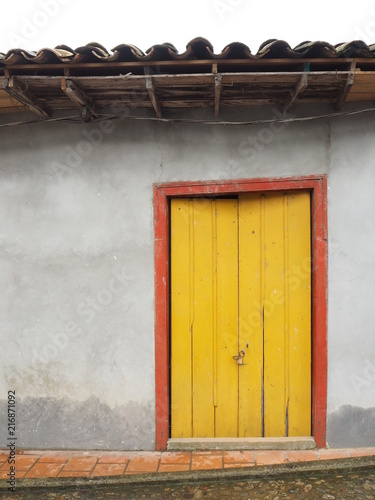 old wooden yellow door in a stone wall