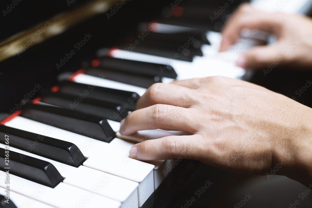Obraz premium close up of hand people man musician playing piano keyboard with selective focus keys. can be used as a background.