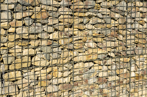 stone rocks in metal and steel wire mesh cages ( gabion ) used in building and construction