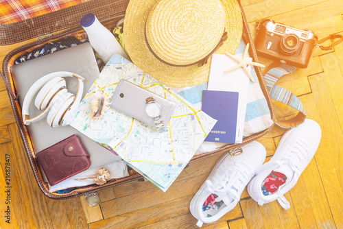 woman staff in suitcase. travel concept. camera laptop wallet hat on floor. overhead view