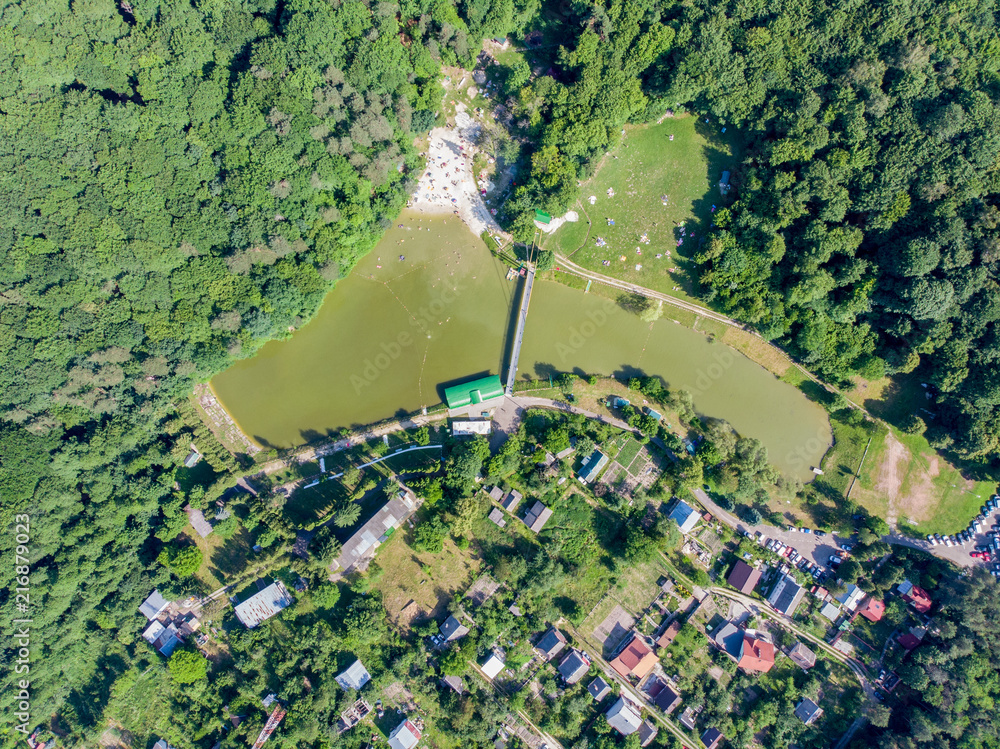 aerial view of lake in forest with sand beach