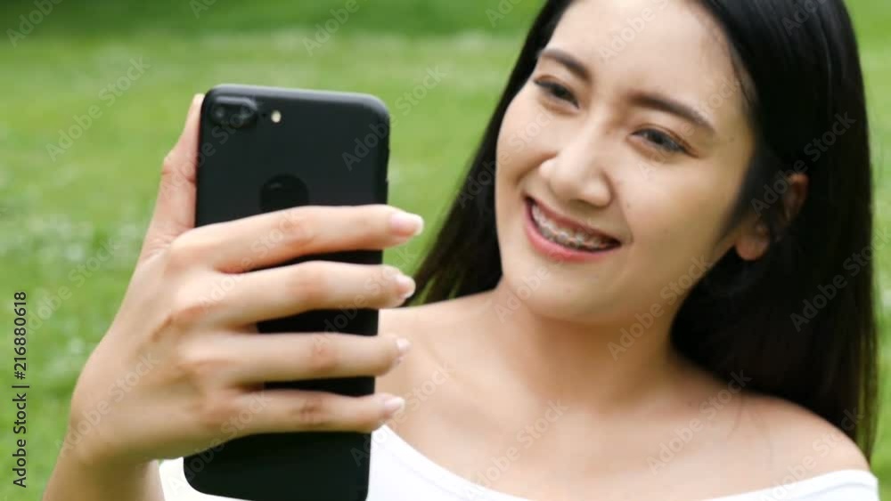 Beautiful asian young woman taking photo selfie using smart phone at public park. Beautiful asian young woman taking photo selfie using smart phone at public park.