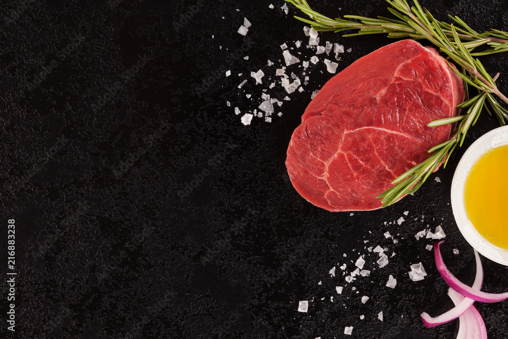 Raw meat, beef steak on black background, top view.