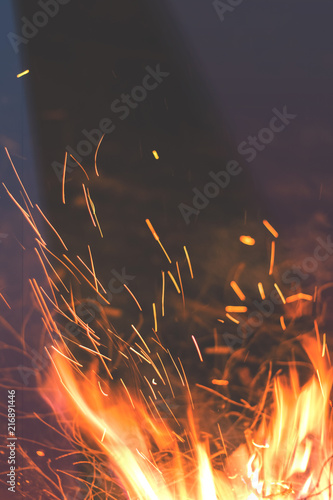 Night bonfire with sparks in motion blur. Toned photo