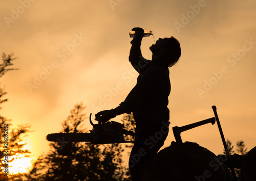 Lumberjack drinking water at sunset