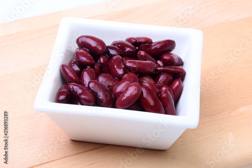 Heap of canned red kidney beans in the sauce in white bowl. vegetarian food. Phaseolus vulgaris. photo