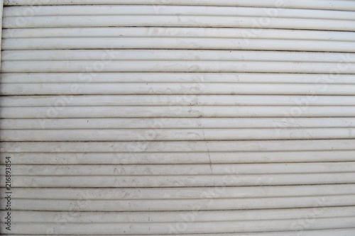 Closeup photograph of white, grungy window blinds.