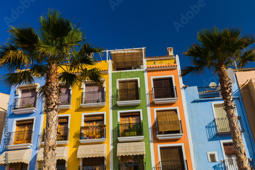 Palm trees on the background Colorful houses in the seaside villa Villajoyosa in southern Spain. photo