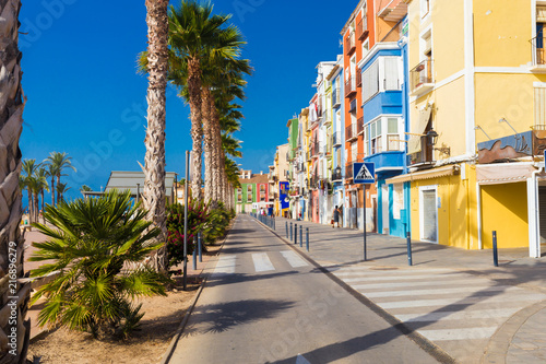 Colourful houses and palm trees on street in Villajoyosa, Spain. photo