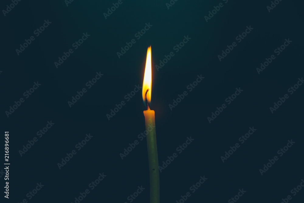 burning church candle on a black background burning church candle on a black background