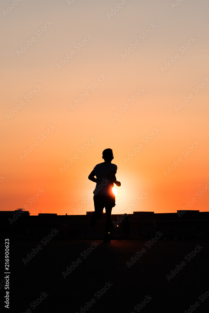 person running towards sunset sky person running towards sunset sky
