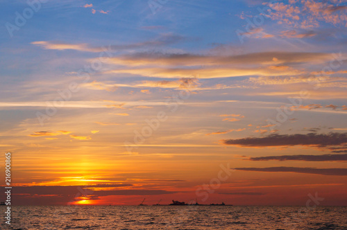 Sunset over the sea. Reflection of sunlight in the sea waves. Red sky in the rays of the sunset.