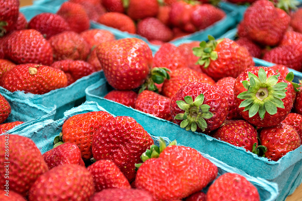 close up of ripe strawberries in turquoise produce boxes at the market close up of ripe strawberries in turquoise produce boxes at the market