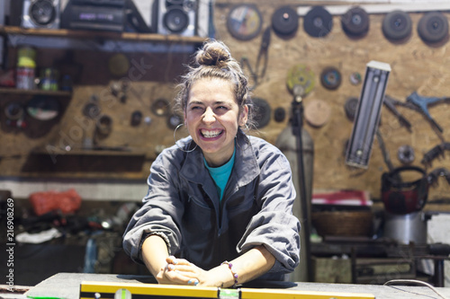 happy young woman working in a workshop photo
