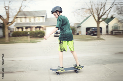 Boy wearing a helmet riding a skateboard, motion blurred image