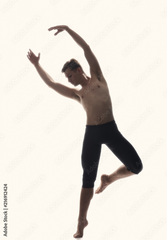 one young man, ballet dancer, standing on one leg in air, white background,  back lit backlighting. white background, studio shot, photo shoot. arms  raised, looking sideways. Stock Photo | Adobe Stock