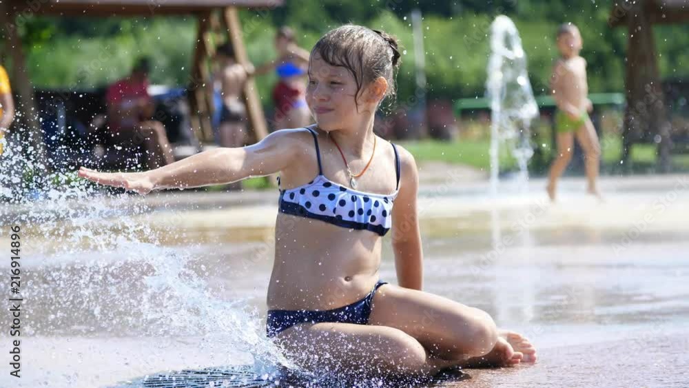 smiling, happy eight year old girl in swimsuit having fun