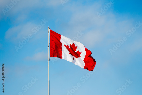 Blue skies with a canadian maple leaf flag in the wind