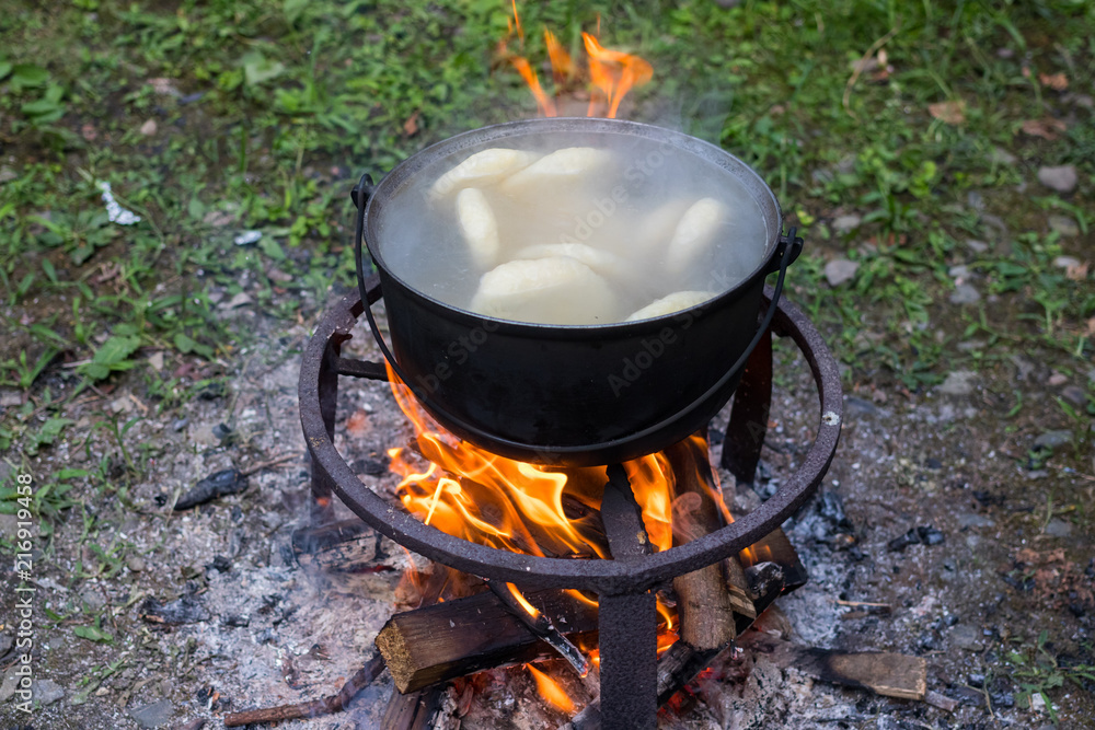 Georgian traditional food. Cooked khachapuri bread pie in a kettle on open fire. Georgian traditional food. Cooked khachapuri bread pie in a kettle on open fire.