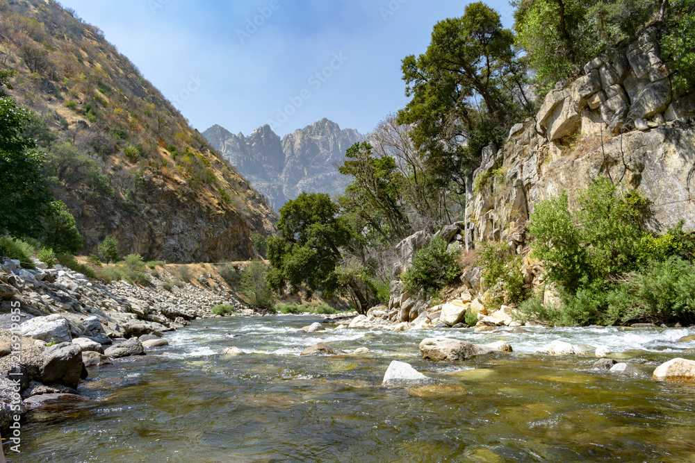 A landscape view of the mountain river in Kings Canyon national Park in California with rigged mountain as background A landscape view of the mountain river in Kings Canyon national Park in California with rigged mountain as background