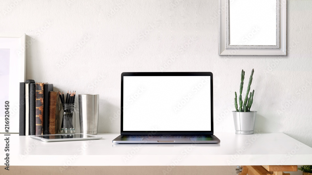 Working space and copy space. mockup poster and blank screen laptop on white desk Working space and copy space. mockup poster and blank screen laptop on white desk