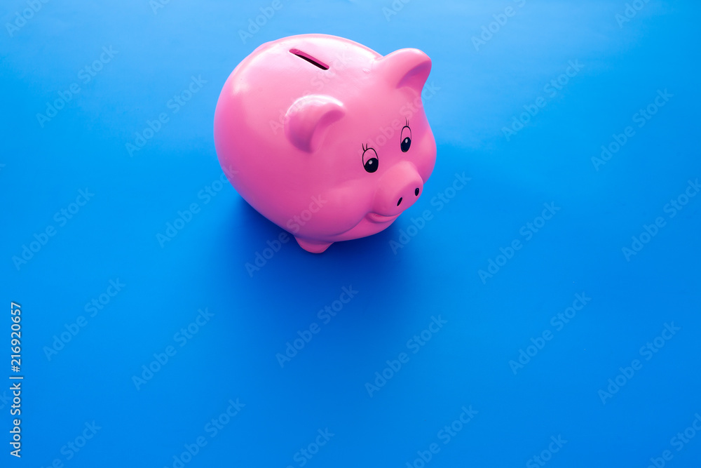 Piggy bank. Moneybox in shape of pig on blue background copy space